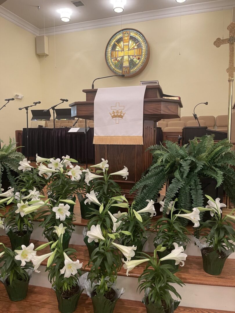 Church altar with flowers and microphones.